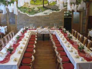 einen langen Tisch mit weißen Tischen und roten Stühlen in der Unterkunft Hotel Brückenmühle in Meiningen