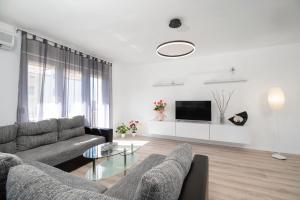 a living room with a couch and a tv at Apartment Suzana in Stobreč