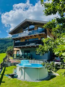 a house with a hot tub in front of it at Apartment WEITBLICK in Wald im Pinzgau