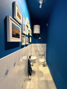 a blue bathroom with a toilet and a sink at Casa Gaia in Marina di Modica