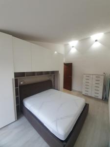 ein Schlafzimmer mit einem großen weißen Bett in einem Zimmer in der Unterkunft Appartamento Stangoni in Badesi