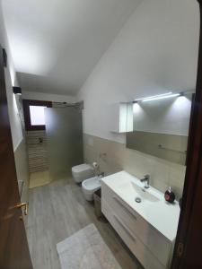 a bathroom with a white sink and a toilet at Appartamento Stangoni in Badesi