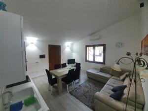 ein Wohnzimmer mit einem Tisch und einem Sofa sowie einem Tisch und Stühlen in der Unterkunft Appartamento Stangoni in Badesi