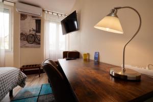 a desk with a lamp and a television on top of it at hotel de la paix in Pamiers