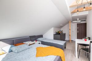 a bedroom with two beds and a desk and a kitchen at SuperApart Obywatelska 42 in Warsaw