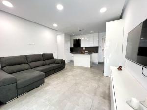 sala de estar con sofá y cocina en Precioso apartamento con piscina a 50m de la playa en Candelaria