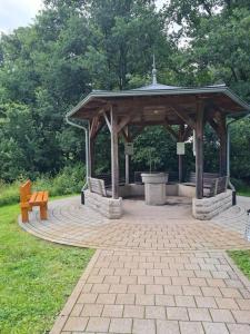 a gazebo with a bench in a park at Ferienhaus Hildegard & Horst - Urlaub im Herzen des Fichtelgebirge in Hohenberg an der Eger +15 photos