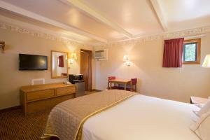 Habitación de hotel con cama y escritorio en Glenwood Springs Cedar Lodge, en Glenwood Springs