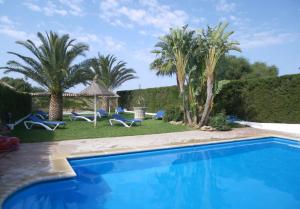 une villa avec une piscine et des palmiers dans l'établissement Hacienda El Romeral, à Zahora