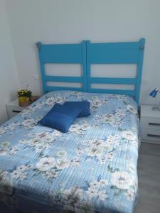 Bett mit blauer Bettdecke und blauem Kissen in der Unterkunft Casa Tulina Appartamenti in Arma di Taggia