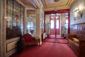 Habitación con silla roja y alfombra roja. en hotel de la paix en Pamiers