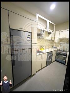 a young boy standing in a kitchen with a refrigerator at شقق بانوراما شاطئ الأسكندرية كود 8 in Alexandria