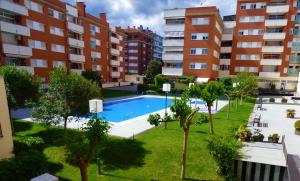 an apartment with a swimming pool in a building at Fenals Beach & Pool in Lloret de Mar