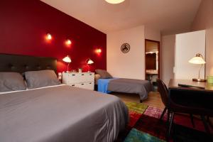 een slaapkamer met 2 bedden en een bureau. bij hotel de la paix in Pamiers