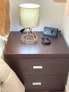 a nightstand with a lamp and a clock on it at La Petite Maison in Monastir +8 photos
