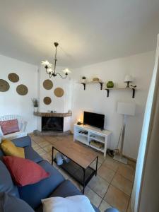 un soggiorno con un divano blu e un tavolo di Agradable casa rural con chimenea en interior a Higuera de la Sierra
