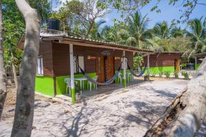 a house with a hammock in front of it at Eco Hotel Bosque Encantado in Isla Grande