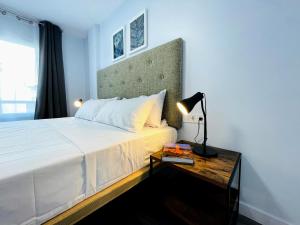 a bedroom with a bed and a table with a lamp at CASA SOHO Y ALEX in Estepona