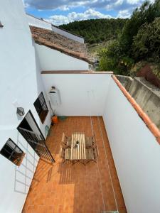 un balcón con sillas y una mesa en el techo en Agradable casa rural con chimenea en interior, en Higuera de la Sierra