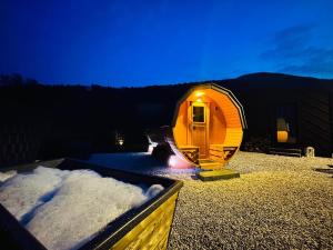 a small tent sitting in the snow at night at Voralpen Lodge - Ferienhaus mit Gym, Sauna & Hot Tub in Traisen