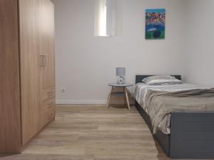a bedroom with a bed next to a wooden cabinet at Apartamentos São Gião 10 in Tomar