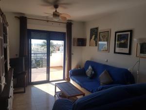 モハカルにあるApartamento La Perla Azulのリビングルーム(青いソファ、ガラスの引き戸付)
