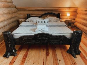 a black bed in a room with wooden floors at Bordeiul Legionarilor in Vatra Dornei