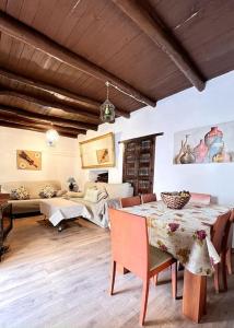 uma sala de jantar com uma mesa e um sofá em Casa La Fuente em Jabugo