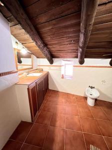 a bathroom with a toilet and a sink at Casa La Fuente in Jabugo