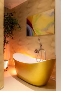een geel bad in een badkamer met een schilderij bij Appartements an der Therme in Bad Ems