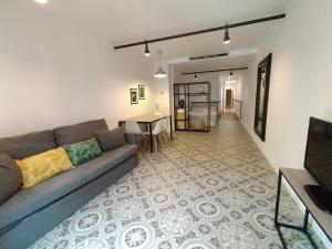 - un salon avec un canapé et une table dans l'établissement Liceu Apartments by gaiarooms, à Barcelone