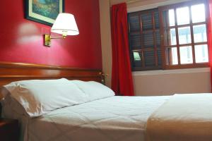 a bedroom with a bed and a red wall at Hotel Splendid in Buenos Aires