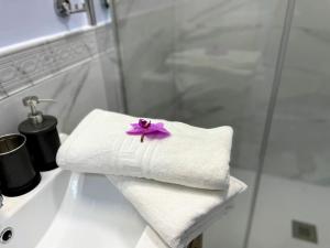 a towel with a flower on top of a bathroom sink at CASA SOHO Y ALEX in Estepona +43 photos