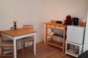 a kitchen with a table and a table and a refrigerator at Puken Apartment in Grömitz