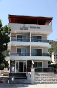 a large white building with a staircase in front of it at Keyf Konak Boutique Hotel in Aydın