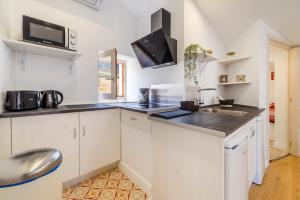 Menditzu Rooms في Biniaraix: مطبخ مع دواليب بيضاء ومغسلة