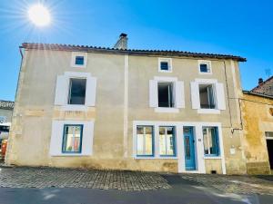 a building with white windows on a street at La Carrée des Amis in Lusignan