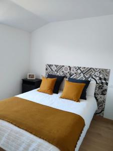 1 dormitorio con 1 cama grande con almohadas amarillas en Casa Rural La Guaxa, en Covielles