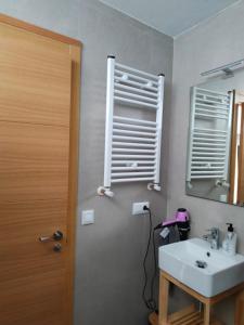 baño con lavabo, espejo y puerta en Casa Rural La Guaxa, en Covielles