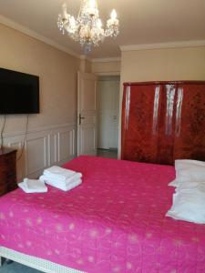 カンヌにあるCannes Mimosas One Bedroomのベッドルーム1室(ピンクベッド1台、シャンデリア付)