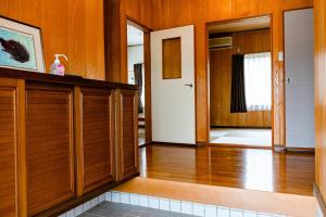 Zimmer mit Holzwänden, Holzböden und einem Flur in der Unterkunft Tomabari Guest House - Vacation STAY 15604v in Sanuki