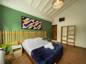 a bedroom with a bed and a painting on the wall at Hotel Casa Las Palmas in Medellín