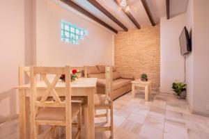 uma sala de jantar com uma mesa e um sofá em Precioso apartamento en Triana em Sevilha