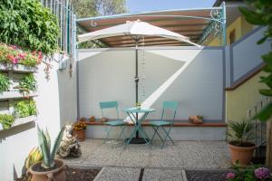 a patio with two chairs and an umbrella at Casa d'aMare - a 600 mt dalla spiaggia in Follonica