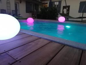 孔东AU PLAISIR D ETAPE- ACCUEIL PELERINS uniquement的水中带粉红色灯光的游泳池