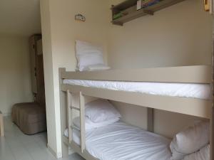 two bunk beds in a room with white sheets at horizon sur mer 1137 in Saint Pierre La Mer
