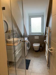 ein Bad mit einem Waschbecken, einem WC und einem Fenster in der Unterkunft Apartments Braunschweig - Charlys Home - Küche - Fachwerk - Familie in Braunschweig