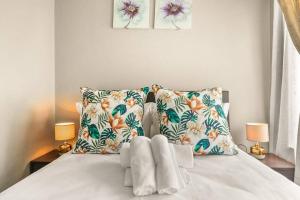 ein weißes Bett mit zwei Kissen und zwei Lampen in der Unterkunft V&S Apartments - Lovely 2 bedroom in Fourways, Johannesburg in Midrand