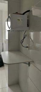 einen weißen Kühlschrank mit einer Schachtel darüber in der Unterkunft AP, Condomínio, Vista do Mar, Piscina, Estacionamento in Itanhaém