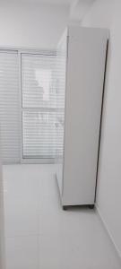 eine weiße Tür in einem Zimmer mit Fenster in der Unterkunft AP, Condomínio, Vista do Mar, Piscina, Estacionamento in Itanhaém
